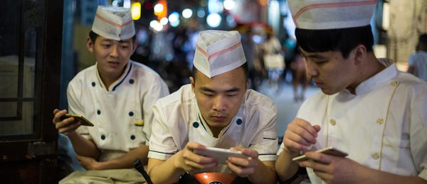 Chinese youths play with their smartphones and social media, in Beijing, China. Image shot 2016. Exact date unknown.